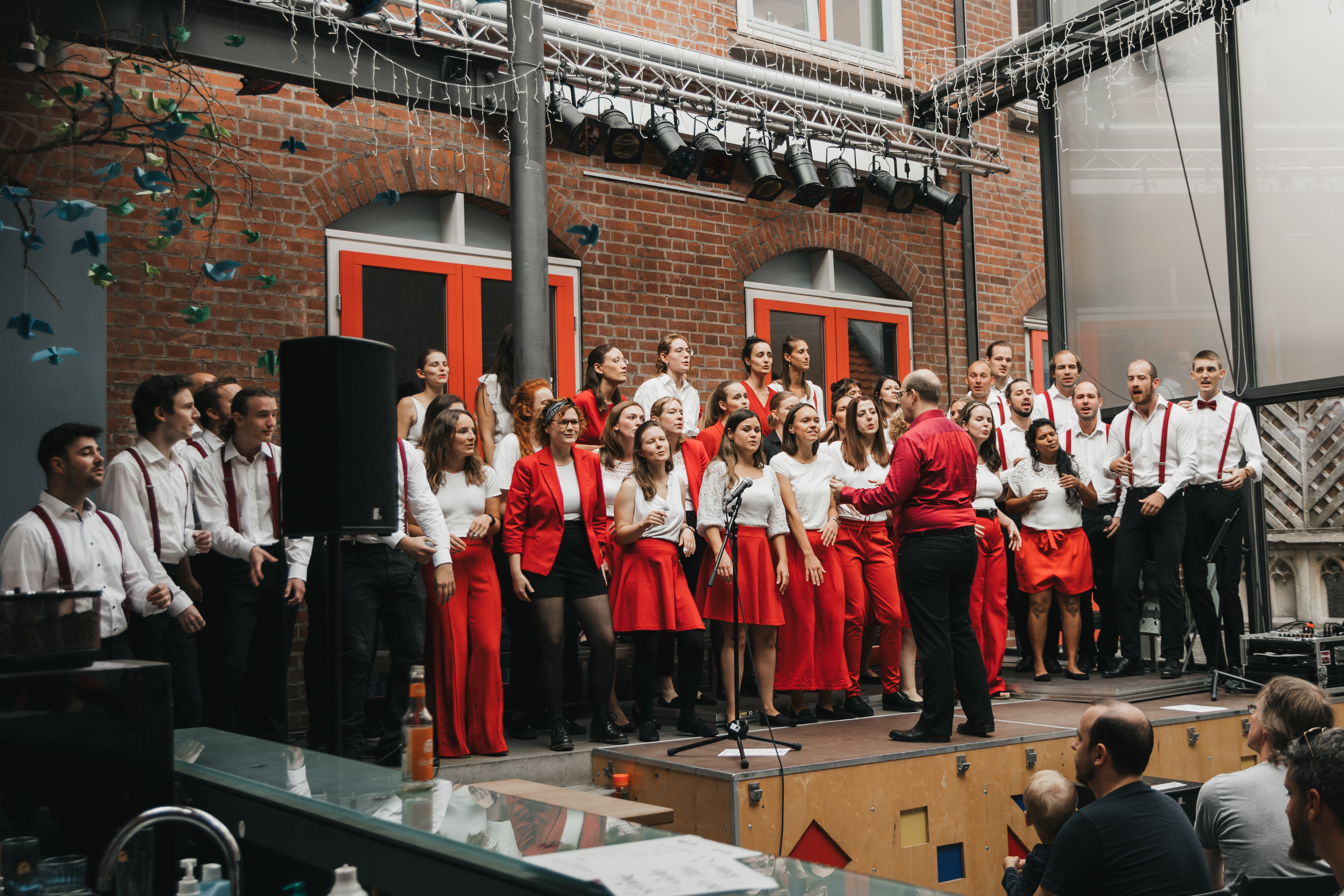 Stadtteilkonzert Mitte im JAM Der Chor steht auf der Bühne des Café JAM und singt